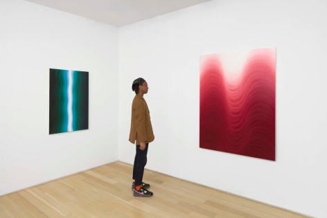 installation view of paintings in a white room