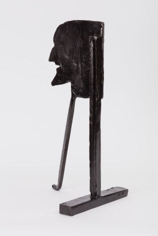 bronze statuette of a man's face on two long supports