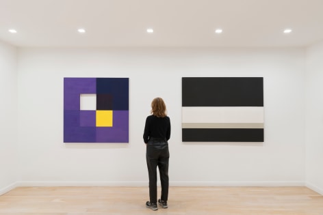 installation view of paintings in a white room