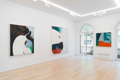 installation view of multiple paintings in a white room