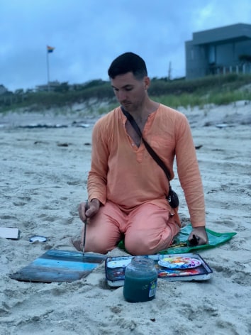 man painting on the beach