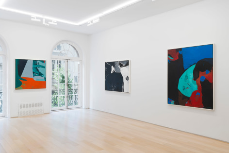 installation view of multiple paintings in a white room