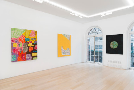 installation view of paintings in a white room