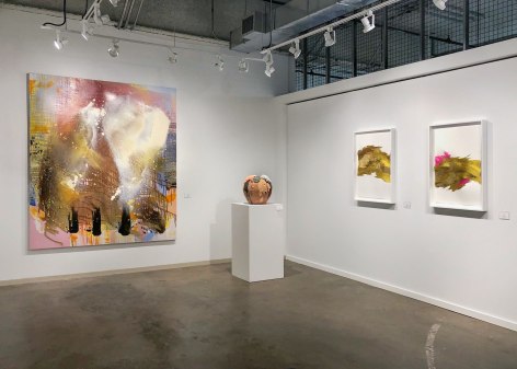 installation view of paintings in a white room