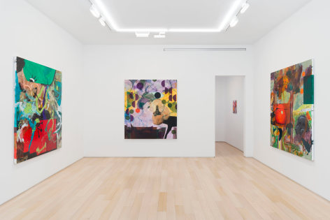 installation view of paintings in a white room