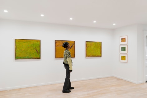 installation view of paintings in a white room