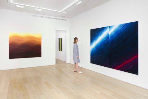 installation view of paintings in a white room