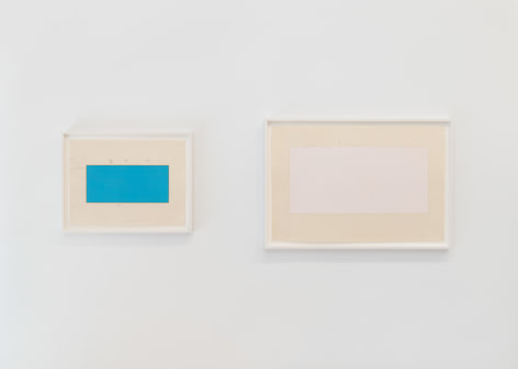 installation view of multiple works on paper in a white room