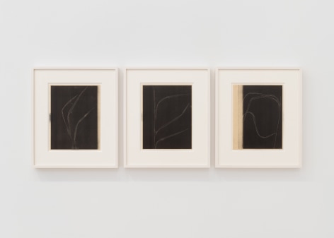 installation view of multiple works on paper in a white room