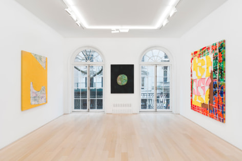 installation view of paintings in a white room