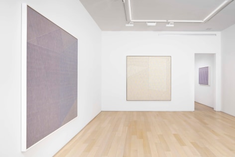 installation view of paintings in a white room