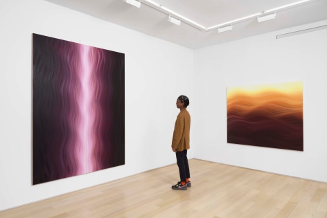 installation view of paintings in a white room