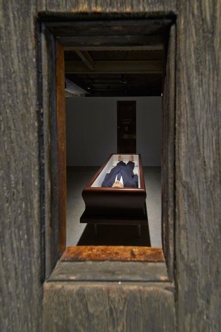 The space is split into seven rooms, with dark-painted walls creating mysterious chambers, each containing a single piece. Pictured is &#039;Now&#039;, 2004