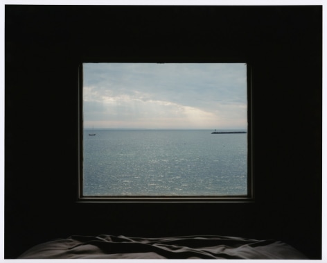Photo showing seascape through darkened window