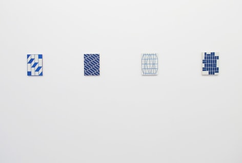 Installation view of four blue and white geometric abstracts