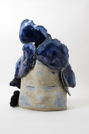 Blue tinted sculpture depicting face with clouds