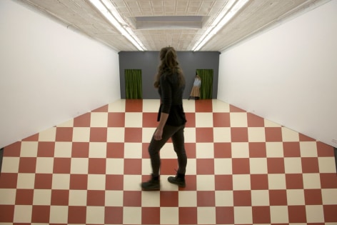 Person walking on red and white checkered optical illusion on gallery floor
