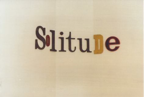 Colored letters on gallery wall spelling 'solitude'