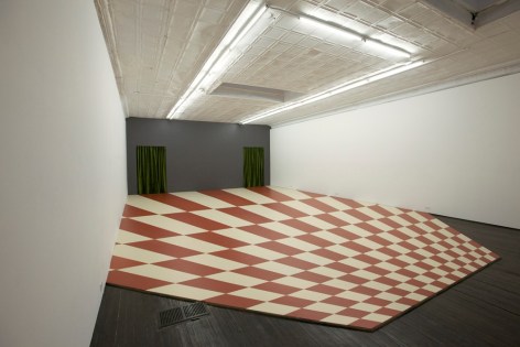 side view of red and white checkered optical illusion on gallery floor