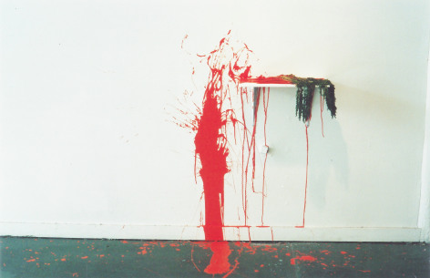View of red painted splattered on gallery wall