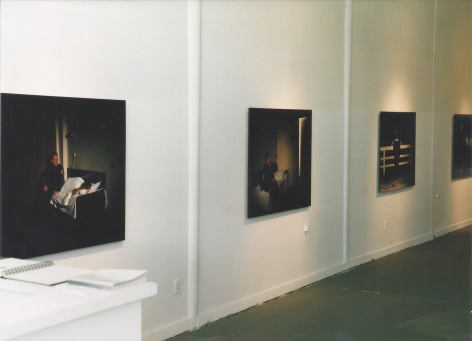 Installation view of darkened photographs