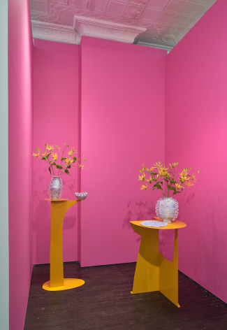 Installation view of two ceramic vases holding flowers