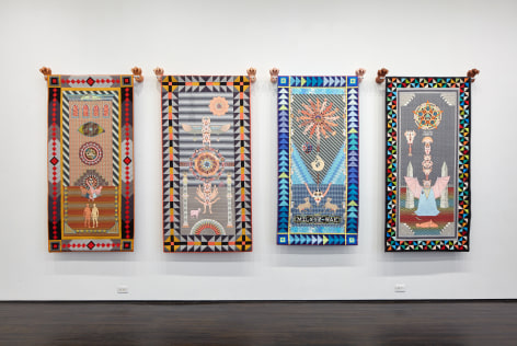 Four wall tapestries hanging on gallery wall