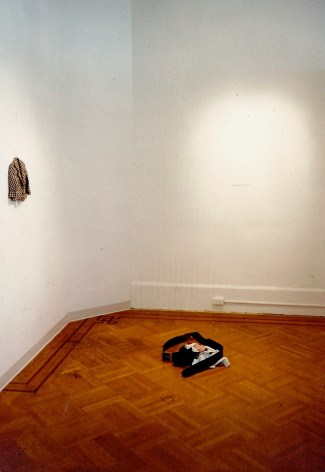 miniature clothing on gallery wall