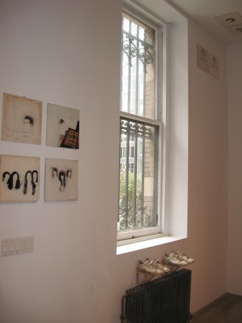 Portraits on gallery wall with shoes underneath
