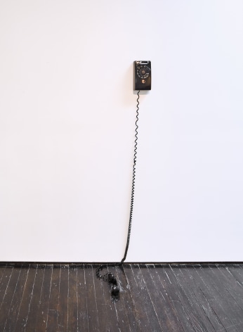 Phone mounted on gallery wall, with receiver hanging