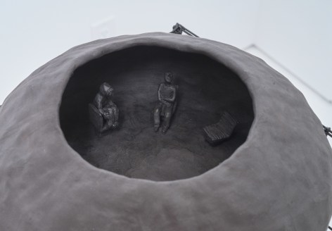 Interior view of black ceramic vase, showing persons sitting in circle