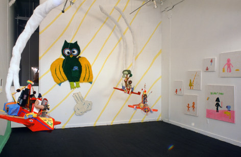 Installation photo of paintings, cloth jets, and owl