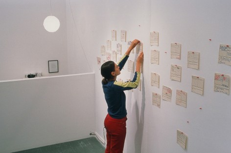 person pinning mixtape to gallery wall
