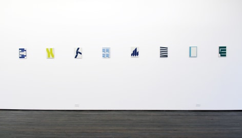 Installation view of eight geometrical abstract works