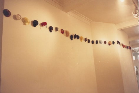 Various hats hung throughout gallery
