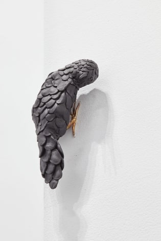 Bird sculpture posed on gallery wall