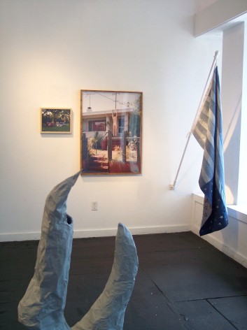 Installation view, sculpture with flag and photographs