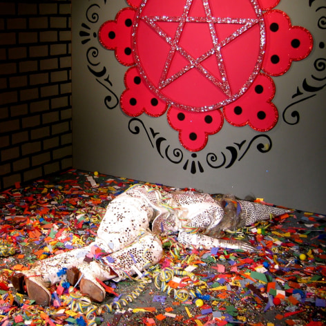 man lying in front of grey room, covered in confetti