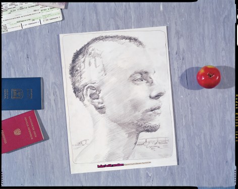 Photo of pencil drawing next to apple and passport