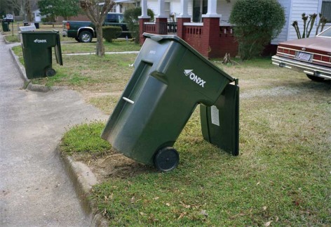 Photo of tilted over green trash can