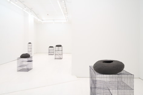 Black vases on wireframe columns, gallery view