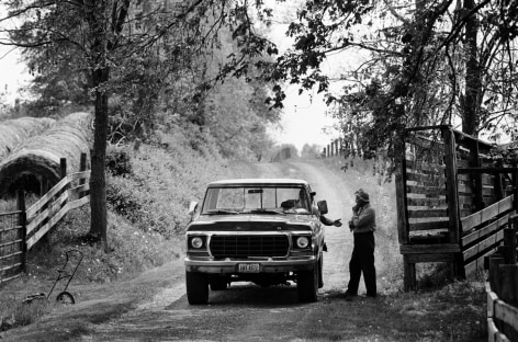 B&amp;W photo of car stopping by fence