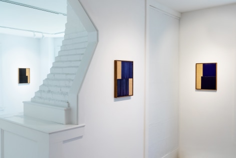 Installation view of three small abstract paintings