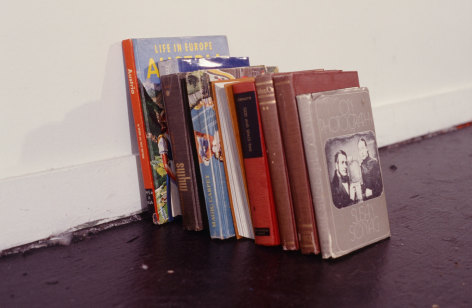 Collection of various hardcover books on gallery floor