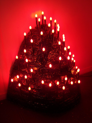 Black plastic lump covered in red lamps