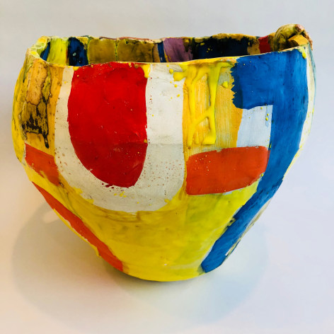 Closeup of red, white, yellow and blue Roger Herman ceramic vase