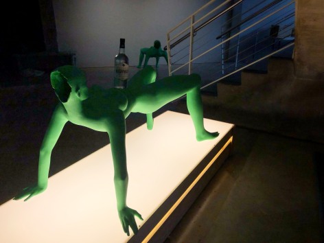 (Description: green female mannequin on illuminated platform)