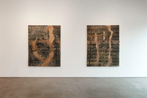 Installation view of Edgar Ramirez Smoke Paintings yellow and gold text with dark browns and blacks