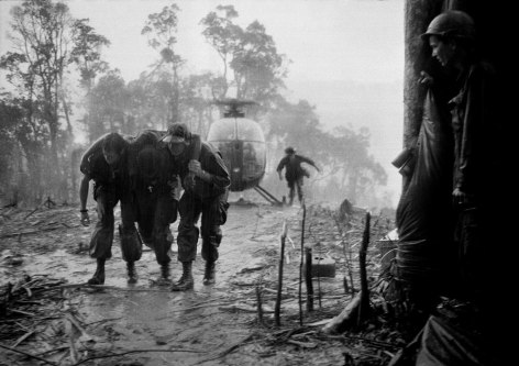 Hugh Van Es- A Wounded Paratrooper of the 101st Airborne Division is Helped Through a Blinding Rainstorm