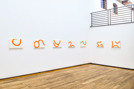 seven white and orange canvases installed on white wall